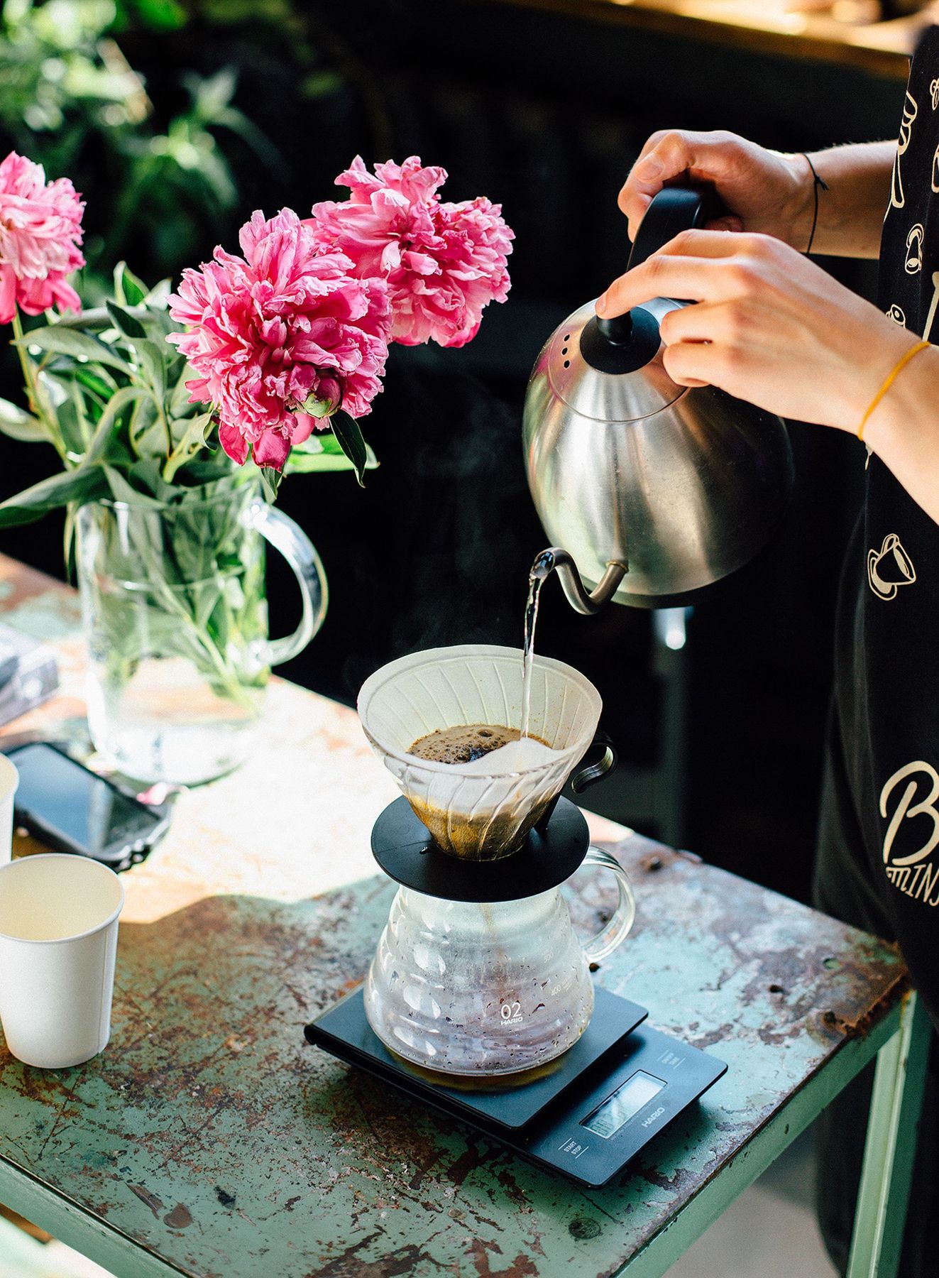 Pour-over coffee with flowers on a café table