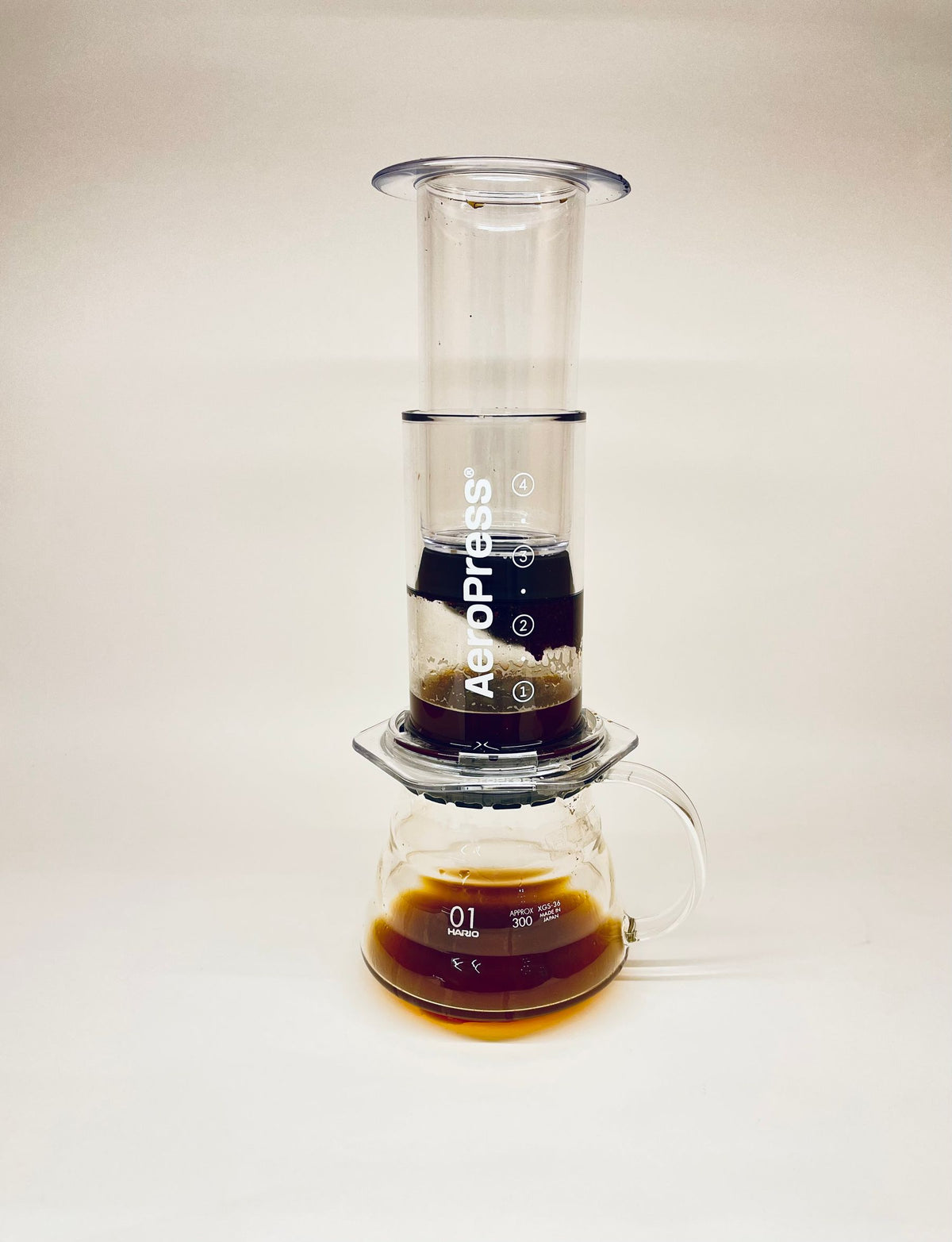 Stock lifestyle photo, not the actual product: aeropress brewing into a glass carafe, shown for AeroPress Genuine Replacement Filters (pack of 350)