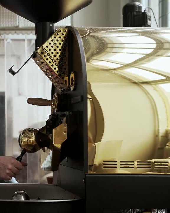 A roaster working a drum roaster